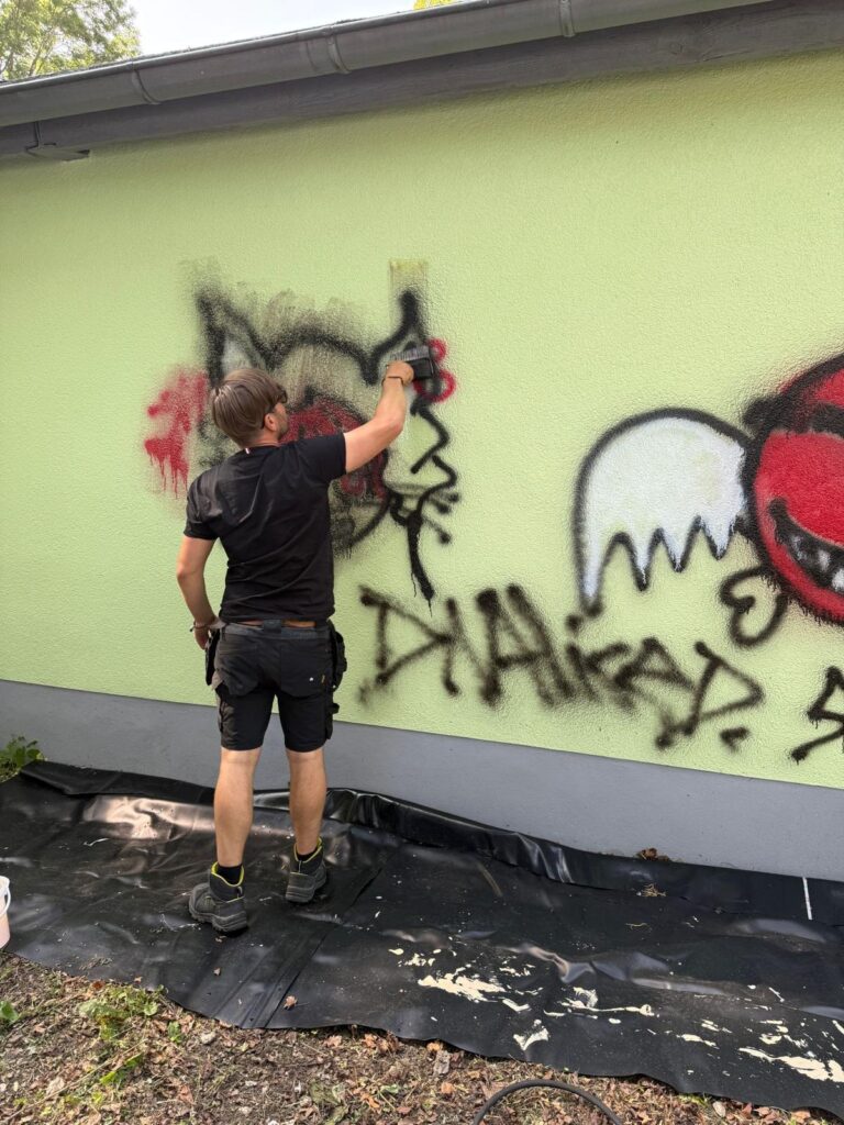 Graffiti entfernen, Mitarbeiter entfernt Graffiti
